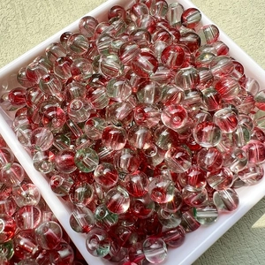 Gros plan de perles bicolores rouge et vert pour la création de bijoux DIY créatifs