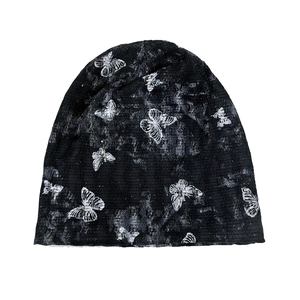 Detail of black butterfly tie-dye beanie with vintage texture and stretch fabric