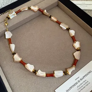Ethnic mother-of-pearl bead necklace with gold lobster clasp in a jewelry box