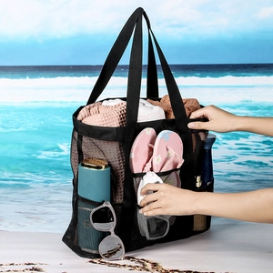 Détail du sac de plage en maille noire avec huit poches contenant des articles d'été