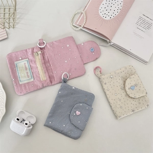 Detail of star-patterned zipper coin purses with heart button and plastic carabiner