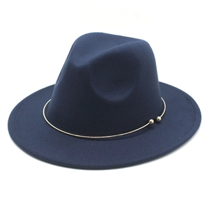 Detail view of navy blue felt fedora with elegant minimalist gold metal ring trim