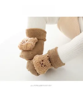 Dettaglio calzini neonato spessi a coste con orsetto di peluche 3D color cammello