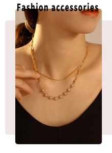 Detail of double-layer golden stainless steel necklace with sparkling heart zircon charms