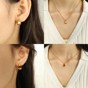 Irregular geometric jewelry set with gold necklace and pearl earrings on model