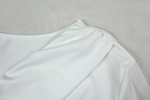Close-up of white dress shoulder with elegant pleated fabric and sheer texture details