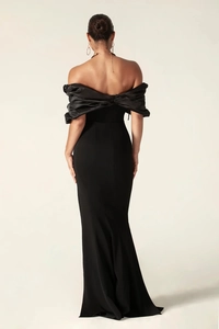 Detail of elegant black off-shoulder evening gown with pleated satin and mermaid hemline
