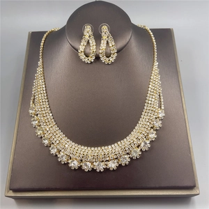 Sparkling rhinestone necklace and teardrop earrings set on dark display stand for brides