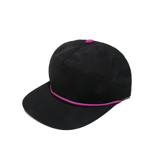 Détail d'une casquette noire à 5 panneaux avec cordelette violette et bouton contrasté