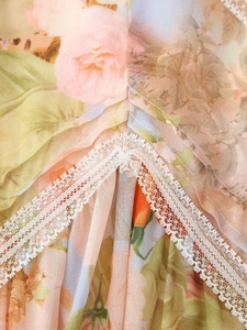 Detailed macro view of floral print fabric and white lace trim on a summer dress