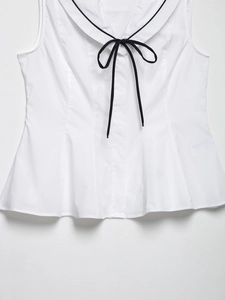Detail of white sleeveless top featuring a sailor collar and black bow tie design