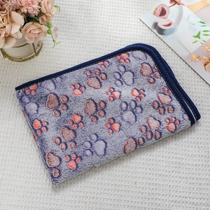 Detail view of purple flannel pet blanket with paw prints on waffle fabric background