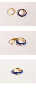 Detail of blue and white enamel open rings with zircon stones in golden frames