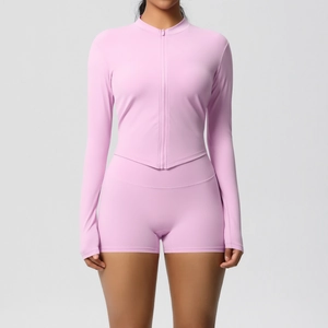 Detail of light pink yoga set featuring a front zipper top and high-waisted fitness shorts