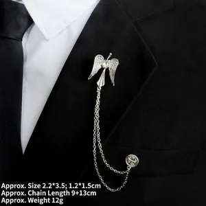 Detail of silver angel wing brooch with hanging chains and rhinestones on suit