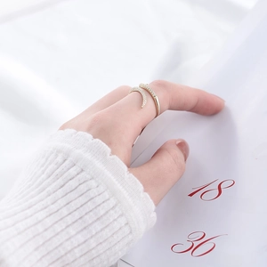 Detail of adjustable gold crescent ring with micro-pave zircons worn on hand