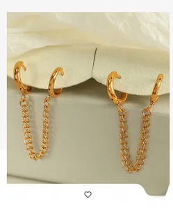 Detailed macro of gold-plated double-chain hoop earrings on a minimalist display stand
