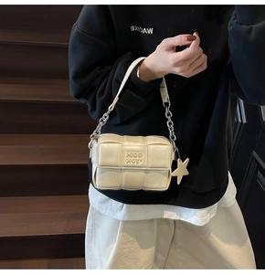 Détail du mini sac tressé crème avec pendentif étoile et bandoulière en chaîne