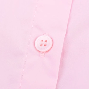 Detailed macro view of pink poplin fabric texture and matching four-hole button on a shirt