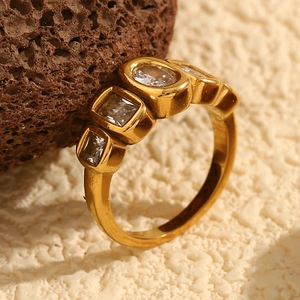 Macro shot of 18K gold-plated ring with geometric cubic zirconia on volcanic stone