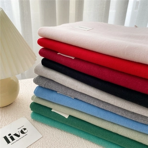 Stack of solid color cashmere scarves in multiple shades with minimalist woven labels