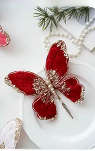 Detail of red velvet Christmas butterfly clip with gold sequins and pearl accents