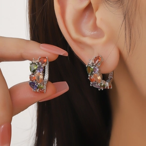 Boucles d'oreilles tendance avec zircons colorés portées par un mannequin de près