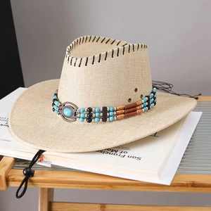 Beige straw cowboy hat with turquoise beads and adjustable chin strap on a white book