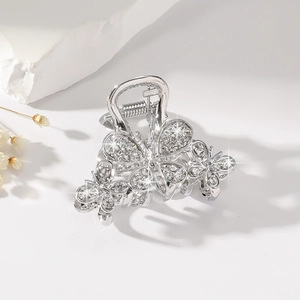 Detail shot of a silver butterfly hair claw clip with sparkling rhinestones on stones