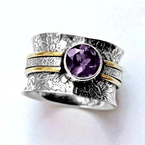Macro shot of vintage silver ring featuring floral carvings and a purple gemstone inlay