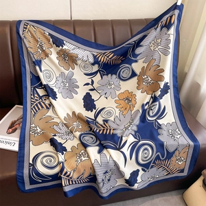 Close-up of floral silk scarf draped on a leather sofa with vintage floral patterns
