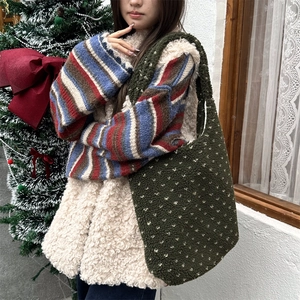 Detail of dark green fuzzy lamb wool tote bag with white polka dots in a winter scene