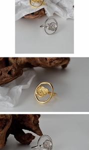 Artistic close-up of irregular gold and silver open rings on natural wood and paper texture