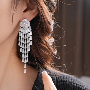 Macro shot of silver-plated long tassel earrings with sparkling geometric zircons