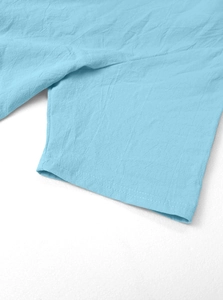 Detail of light blue linen shirt sleeve showing reinforced double stitching and fabric texture