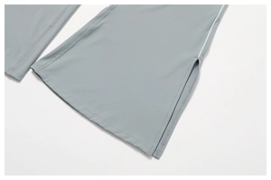 Macro detail of light grey yoga pants featuring side slit hem and fine white contrast stitching