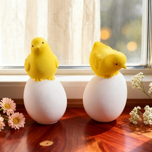 Macro detail of yellow Easter chick figurine on white egg base for home decoration