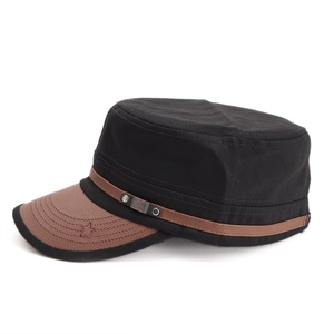 Detail of flat top army cap featuring brown leather brim and metal FS FASHION brand plate