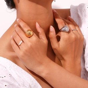 Detail shot of a stackable gold textured dome ring and silver hollow band on hands
