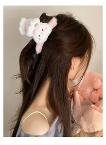 Detail view of a white plush rabbit hair claw clip styled on a model in a half-up hairstyle