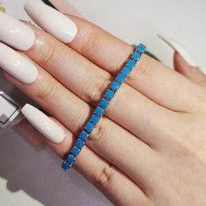 Detail showing the four-claw setting of turquoise tennis bracelet with silver metal