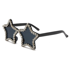 Detail view of star-shaped sunglasses with shimmering rhinestones and black lenses