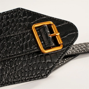 Detailed close-up of wide black crocodile texture elastic belt with golden square buckle