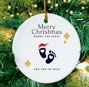 Close-up of white ceramic Christmas tree ornament for new parents with gold cord