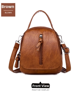 Detailed view of brown leather crossbody bag featuring lychee texture and side tassel