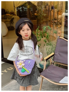 Detail of purple knitted crossbody bag for kids with 3D white flower and pearl strap