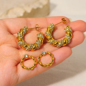 French vintage golden hollow crescent earrings with zircons held by a hand