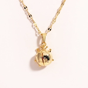 Close-up of golden ladybug pendant with sparkling crystal inlay on a delicate O-chain