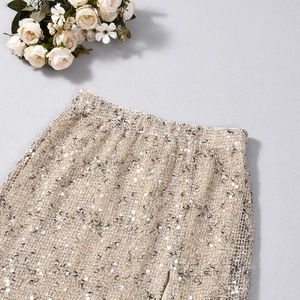 Dettaglio macro del tessuto con paillettes oro champagne e vita della minigonna