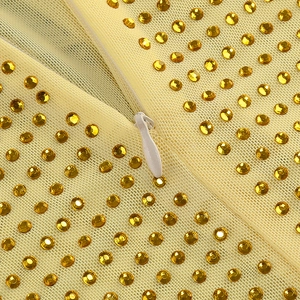 Vue détaillée du tissu mesh jaune avec strass brillants et fermeture éclair blanche